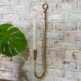 Decorative wall hook with a candle against a brick wall