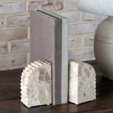 Decorative bookends with textured design on a wooden surface.