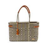 Woven handbag with geometric pattern and brown handle on a white background