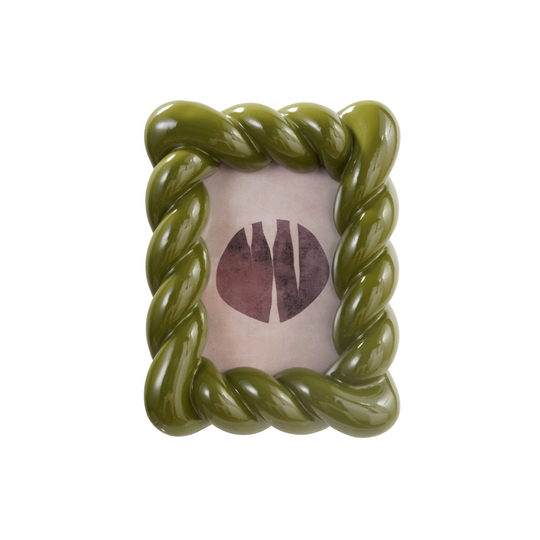 An olive green twisted rope-style picture frame with a glossy finish, holding a light pink card with a dark circular graphic, isolated on a white background.
