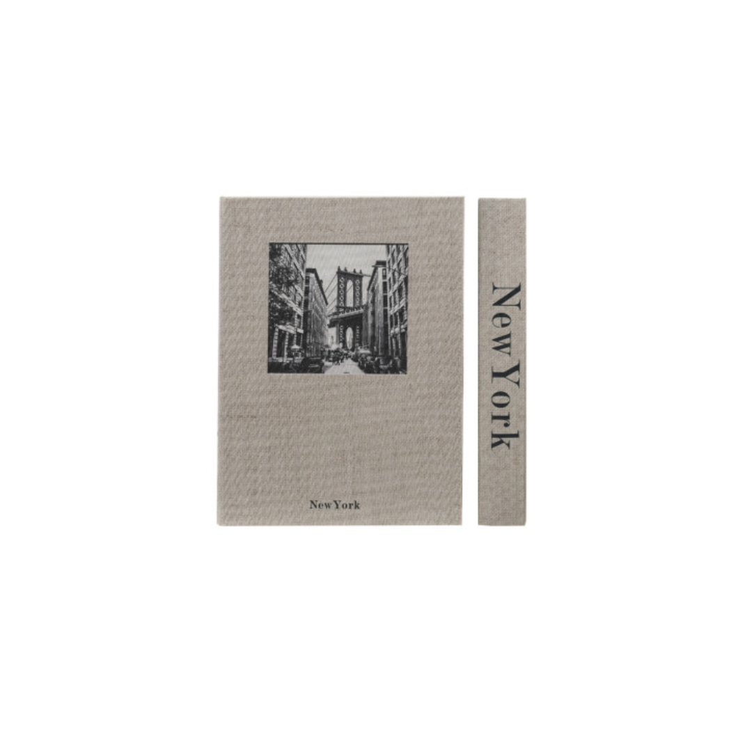 A storage box designed to look like a book featuring a black-and-white illustration of the New York City skyline, shown alongside a narrow matching strip with the text 'New York' printed vertically.