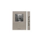A storage box designed to look like a book featuring a black-and-white illustration of the New York City skyline, shown alongside a narrow matching strip with the text 'New York' printed vertically.