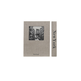 A storage box designed to look like a book featuring a black-and-white illustration of the New York City skyline, shown alongside a narrow matching strip with the text 'New York' printed vertically.