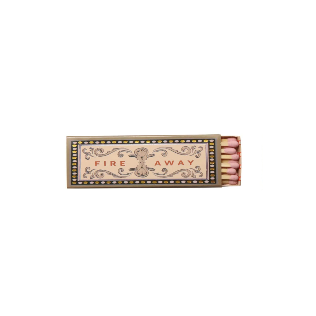 A vintage-style matchbox with ornate scrollwork and the words 'FIRE AWAY' printed on the front, shown open with pink matches visible on a plain white background.