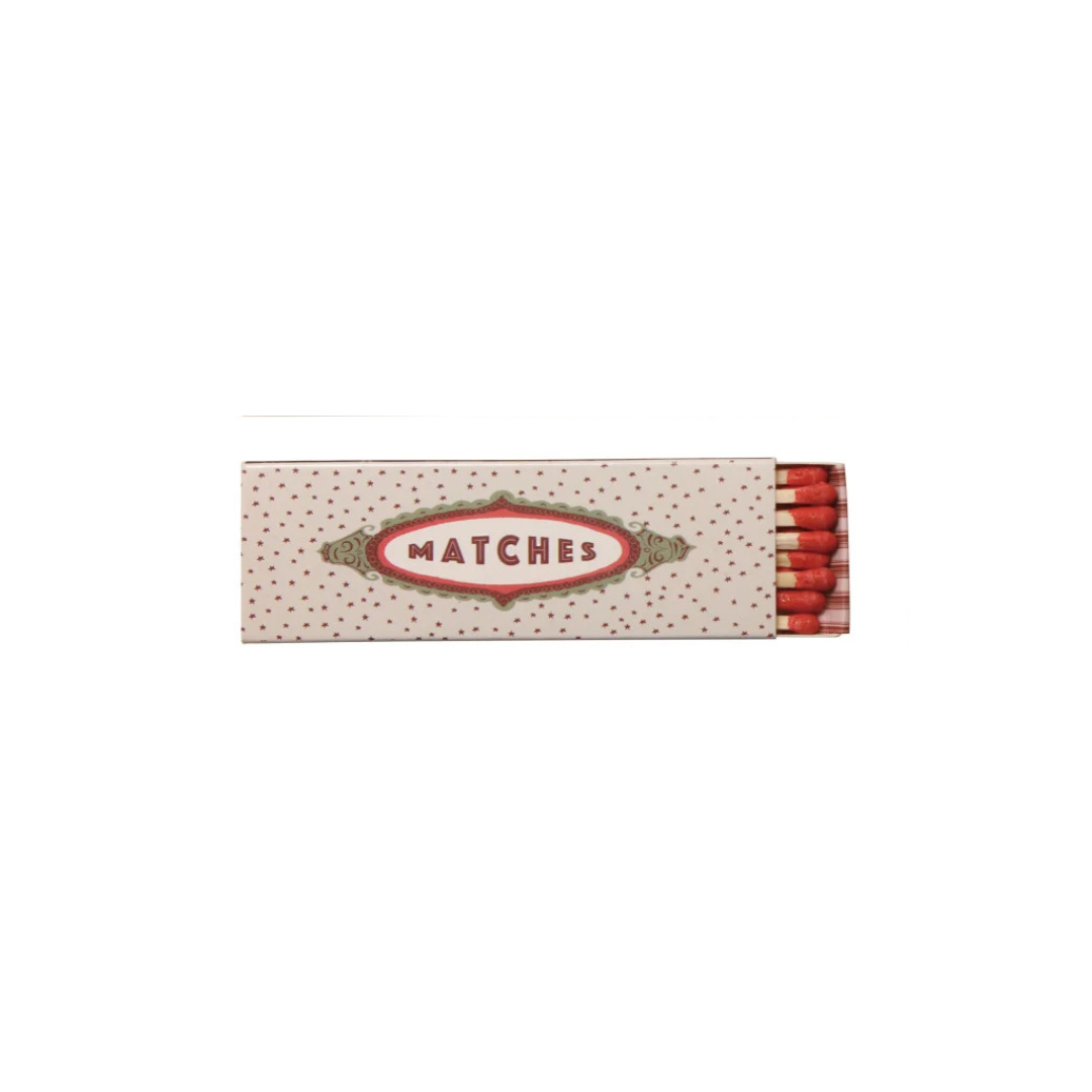 A vintage-style matchbox with a cream-colored cover decorated with small red dots and a central red and gold oval label reading 'MATCHES'. Red matches are visible at the right edge against a plain white background.