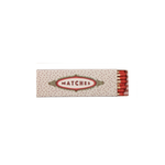 A vintage-style matchbox with a cream-colored cover decorated with small red dots and a central red and gold oval label reading 'MATCHES'. Red matches are visible at the right edge against a plain white background.
