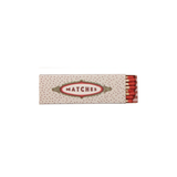 A vintage-style matchbox with a cream-colored cover decorated with small red dots and a central red and gold oval label reading 'MATCHES'. Red matches are visible at the right edge against a plain white background.