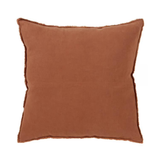 A square throw pillow in a warm rust brown color with a frayed, raw-edge trim, shown against a plain white background.