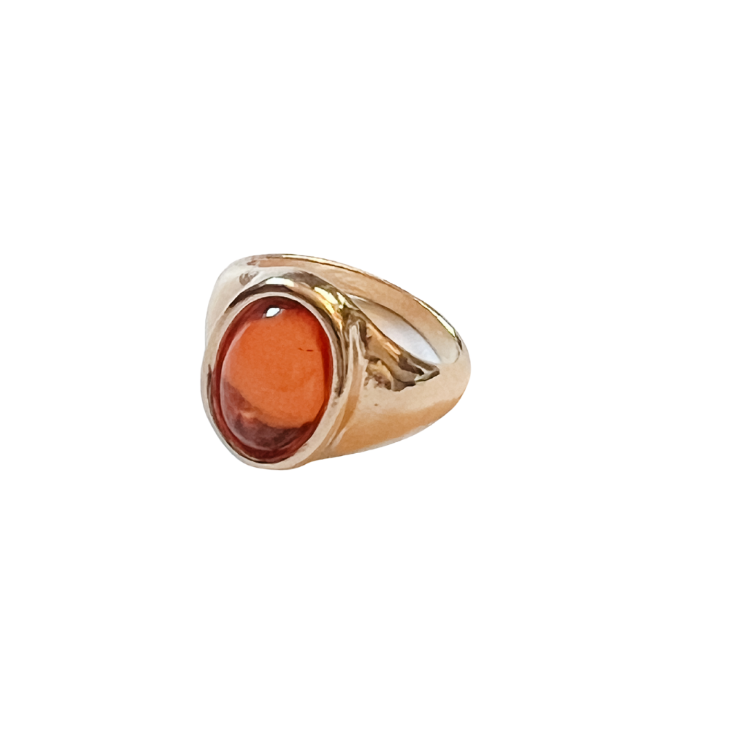 Gold ring with a large amber stone on a white background