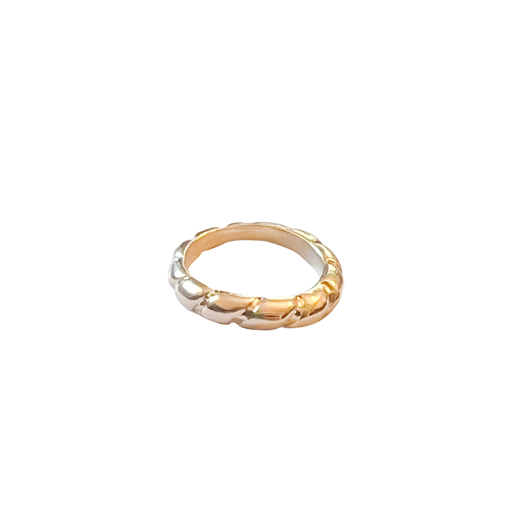 Gold ring with a braided design on a white background
