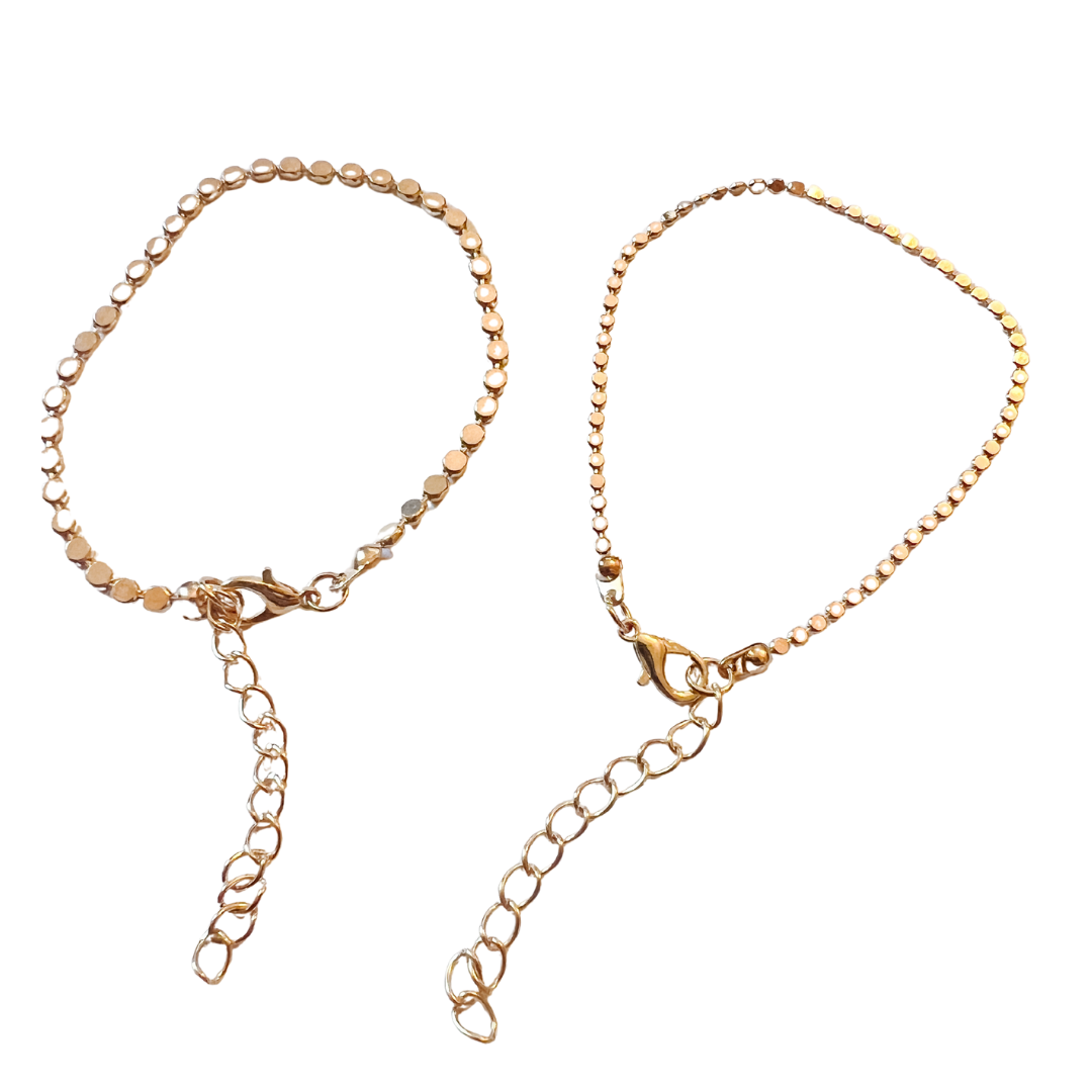 Two gold bracelets on a white background