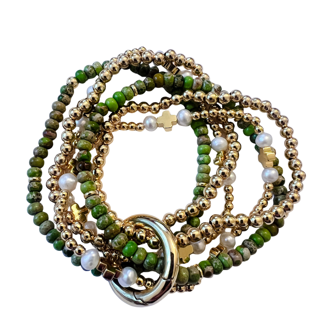 Set of beaded bracelets with green, gold, and pearl colors on a white background