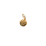Gold pendant with diamond accents on a light beige background