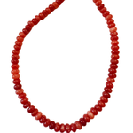 Red beaded necklace on a white background