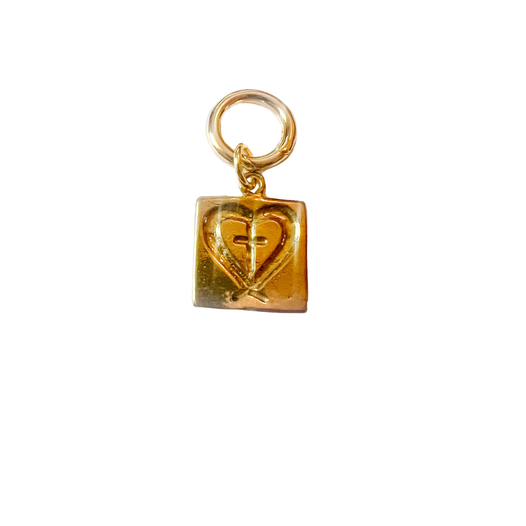 Gold charm with a heart design on a white background