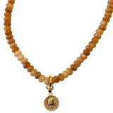Necklace with brown beads and a gold pendant on a white background