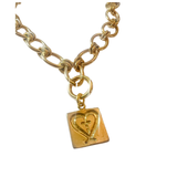 Gold chain necklace with a heart-shaped pendant on a white background