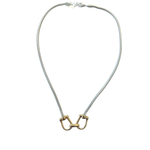 Silver snake chain necklace featuring a gold equestrian horse-bit centerpiece with mixed metal detailing on a white background.