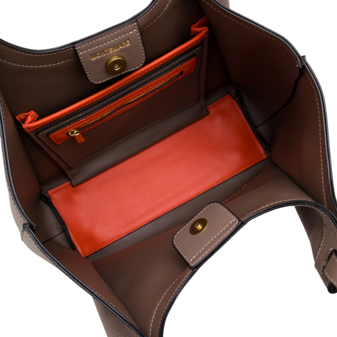 Brown leather handbag with red interior pocket on a white background