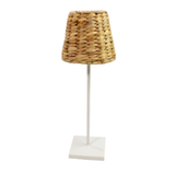Wicker lampshade on a white stand with a white background