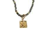 Faceted stone bead necklace with gold accents featuring a removable gold square charm with heart detail.
