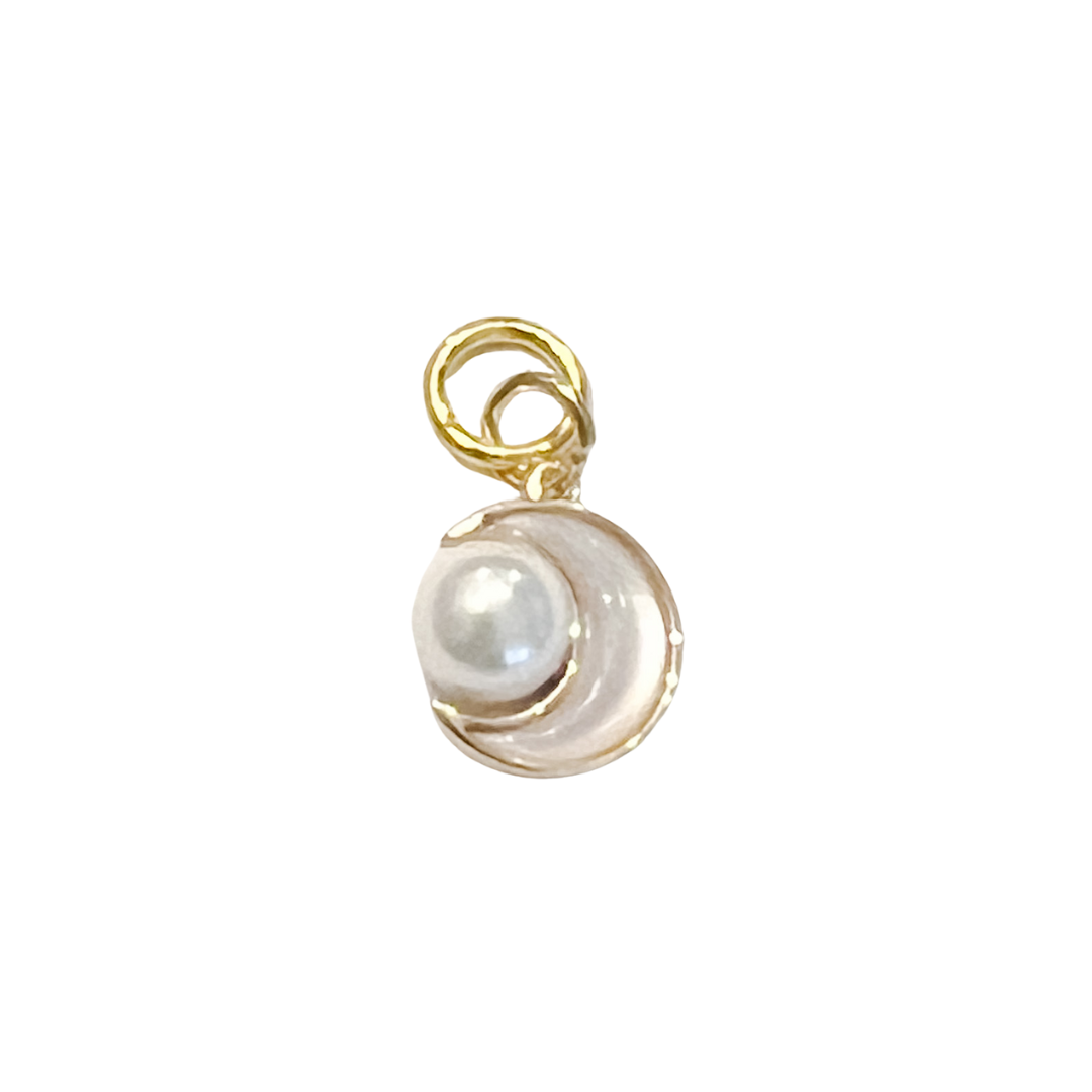 Gold crescent charm holding a white pearl, shown hanging from a beaded necklace on a white background.
