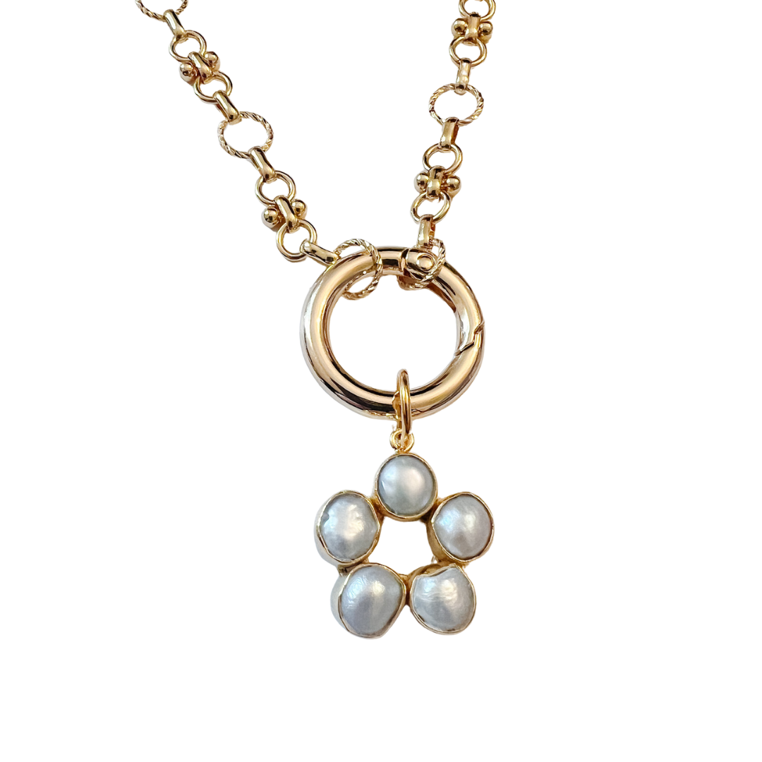 Pearl cluster charm with gold bezel detail hanging from a gold link necklace on a white background.