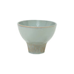 glazed ceramic wide flared  pedestal bowl with ribbed textured base on white background
