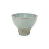 glazed ceramic wide flared  pedestal bowl with ribbed textured base on white background