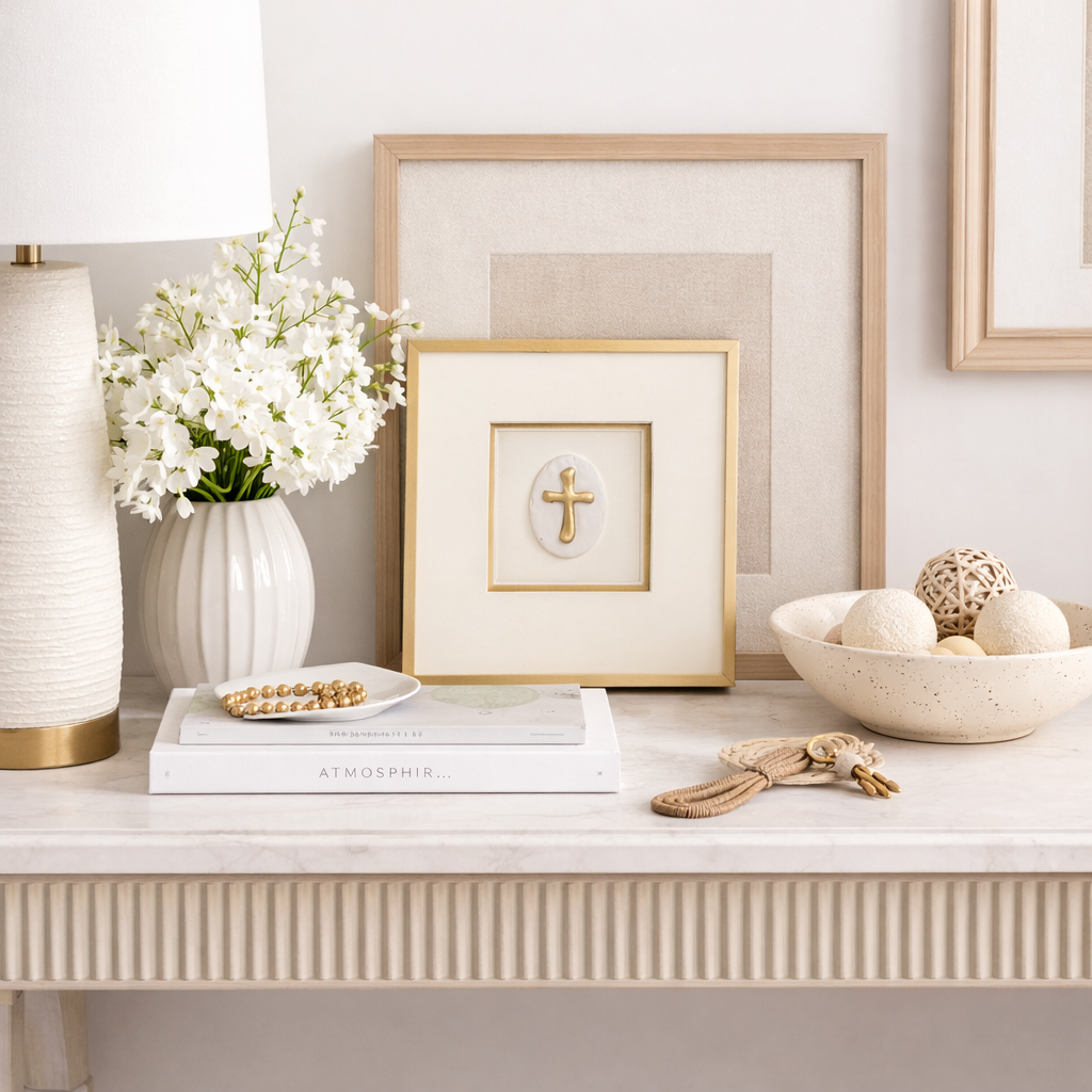 Decorative table setting with framed artwork, flowers, and decorative items on a white surface.