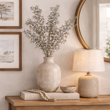 Decorative setup with a vase, lamp, and books on a wooden surface.