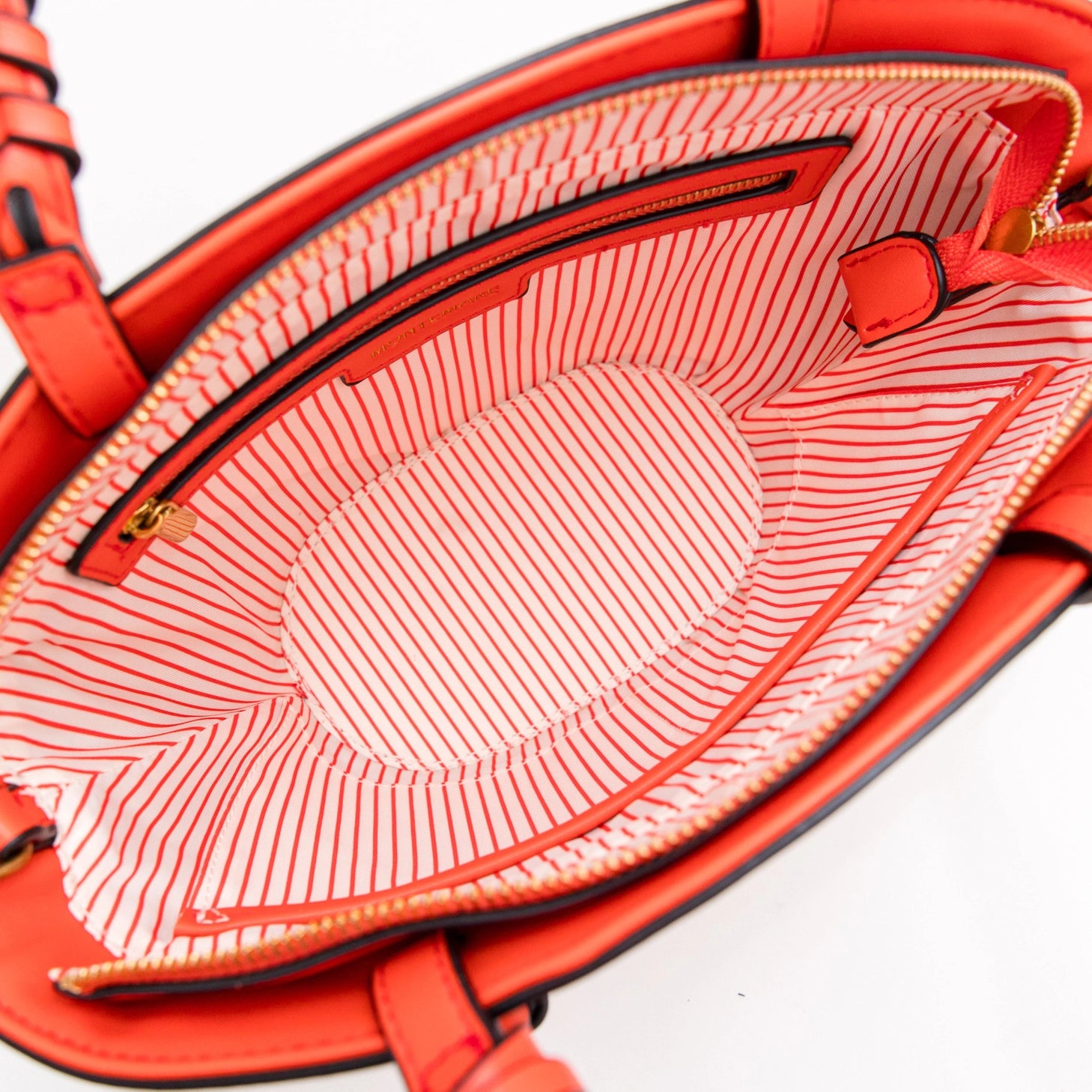 Close-up of a Montemare Palma Crossbody with orange leather accents with a textured interior on a white background