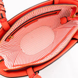 Close-up of a Montemare Palma Crossbody with orange leather accents with a textured interior on a white background