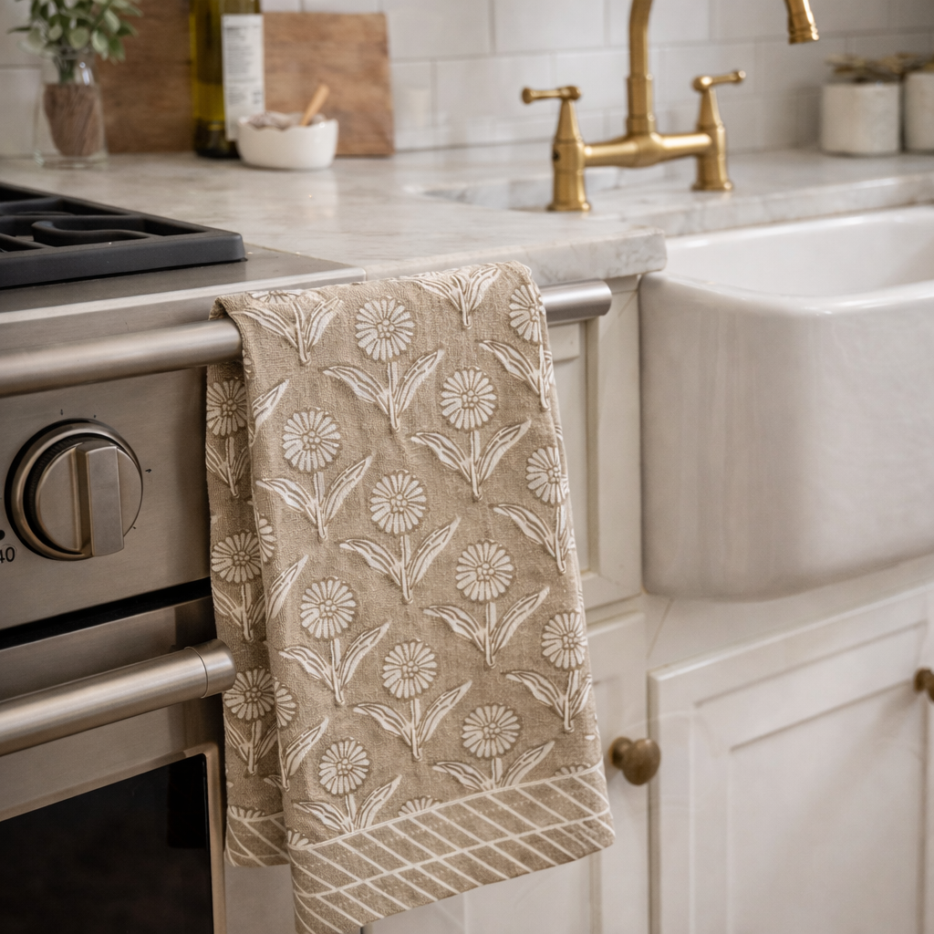 Kitchen towel with floral pattern hanging on a kitchen cabinet handle.