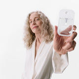 Person holding a clear bottle labeled 'Touchland Power Mist' against a white background