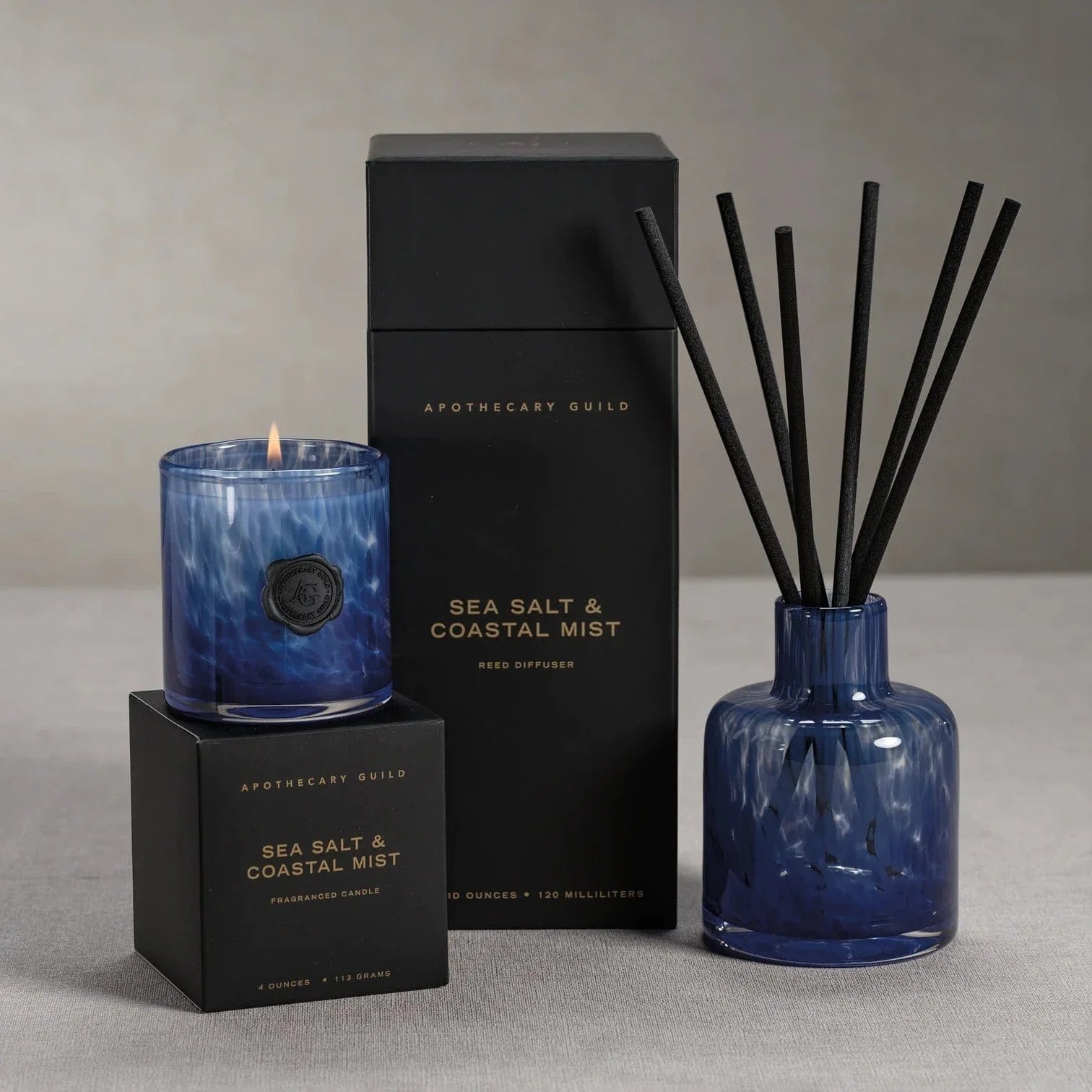 Aromatherapy set with candle, diffuser, and packaging labeled 'Sea Salt & Coastal Mist' by Apothecary Guild.
