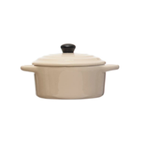Beige ceramic cooking pot with a black lid on a white background