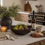 Kitchen counter with a bowl of fruit, wine bottle, and charcuterie board.
