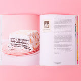Open book with a cake illustration on a pink background