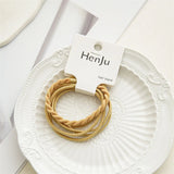 Three yellow hair bands on a white plate with 'HenJu' packaging.