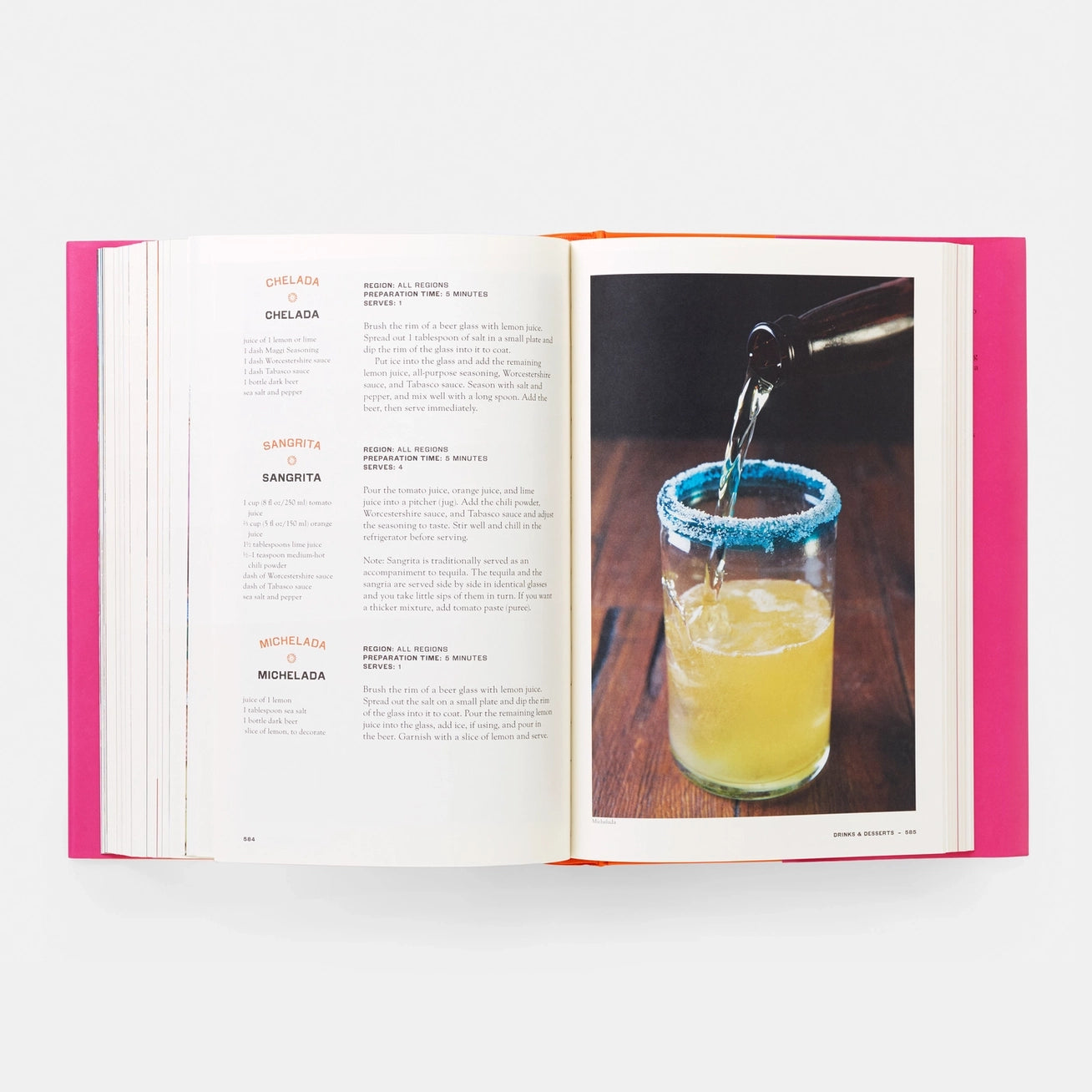 Open book with a page showing a cocktail recipe and another with a cocktail being poured into a glass.