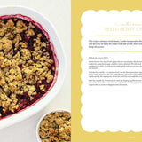 Berry cobbler in a dish with a recipe card on a yellow background