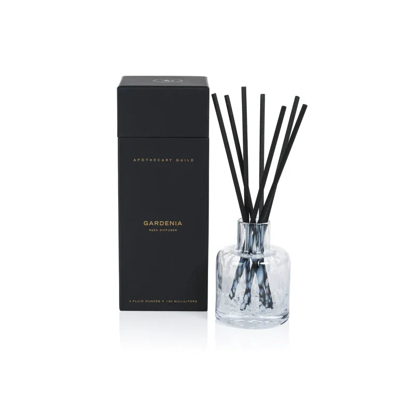 Aromatherapy diffuser with black sticks and clear container on a white background