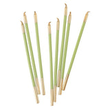 Set of green candles with gold tips on a white background