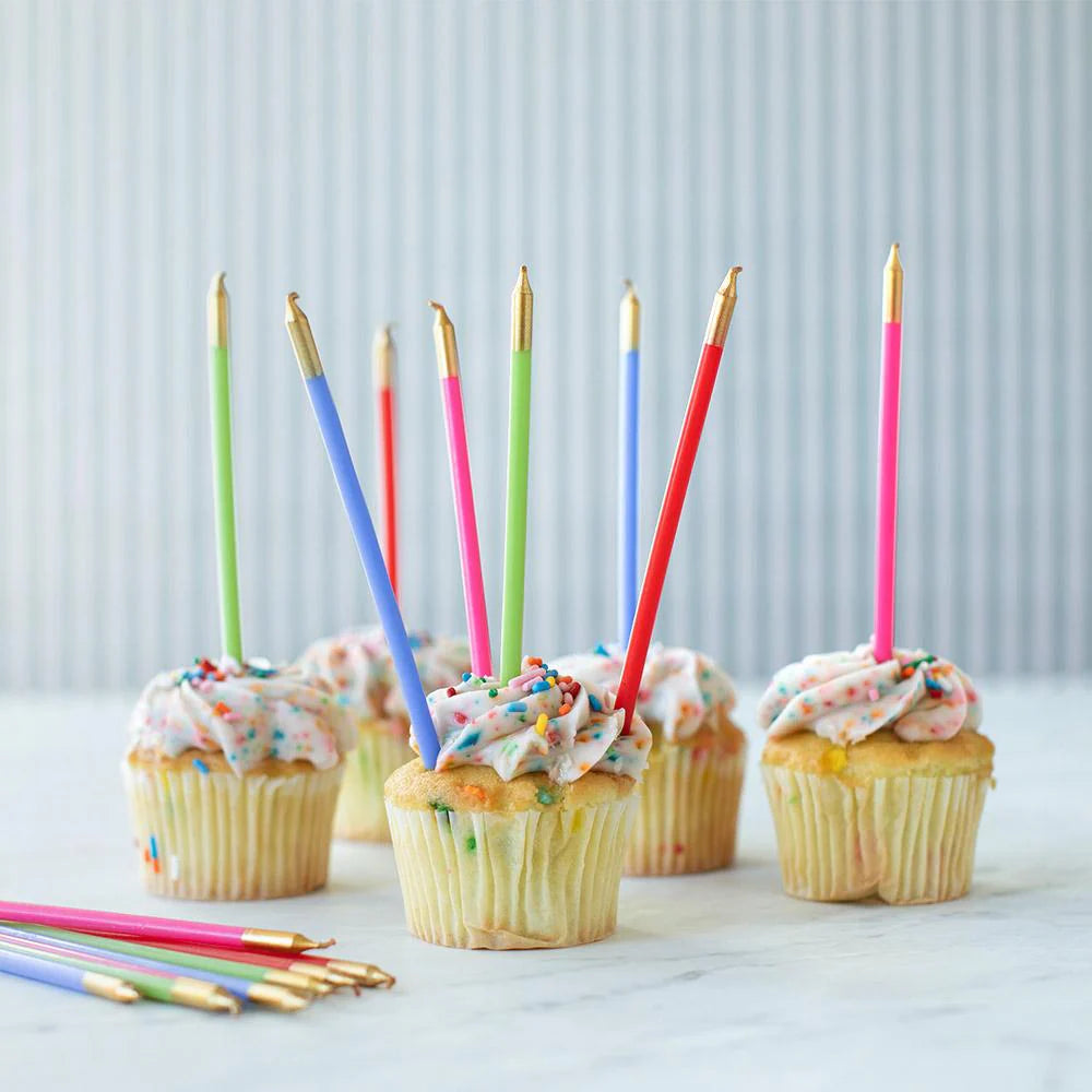 Cupcakes with colorful candles on a light background