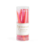Tube of birthday candles with pink and orange colors on a white background