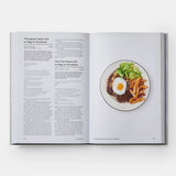 Open book showing a recipe with an image of a dish on a white background