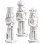 Three white ceramic nutcrackers on a white background