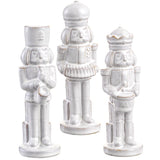 Three white ceramic nutcrackers on a white background