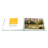 Open book showing a photo of people in Central Park with a yellow square labeled 'New York City'.